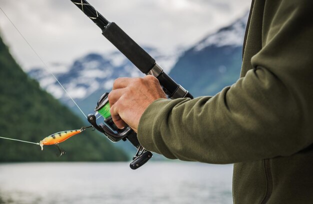 Foto un pescador con una caña de pescar con un carrete giratorio