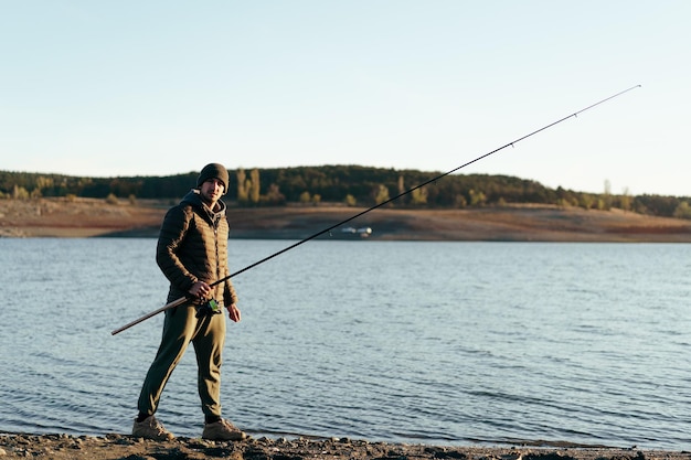 Pescador con caña de pescar en el lago