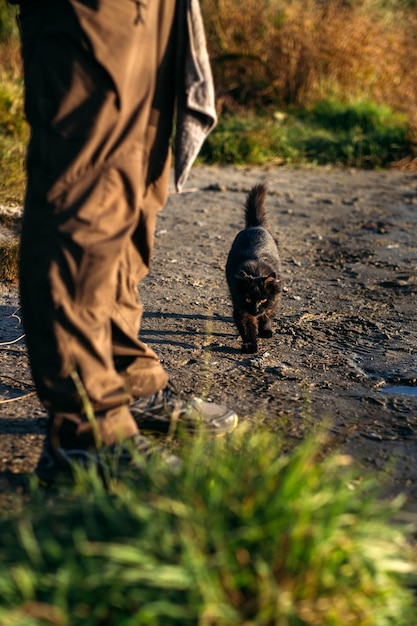 Pescador com vara de giro e gato perto dele no fundo da natureza homem pescador com giro de pesca