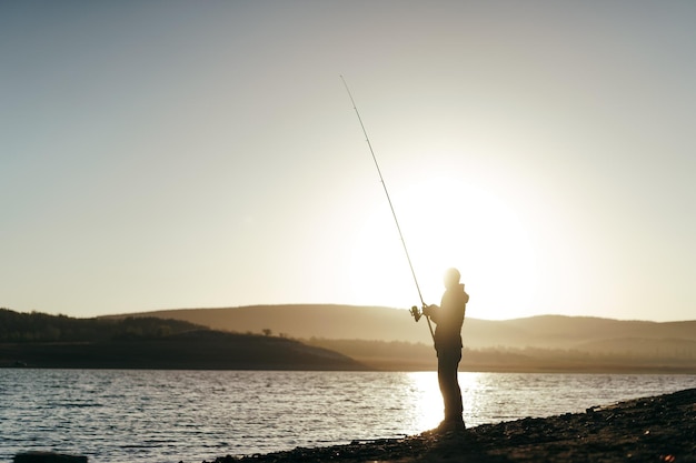 Foto pescador com vara de pescar no lago