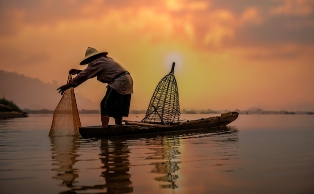 Pescador do lago em ação quando pesca, Tailândia