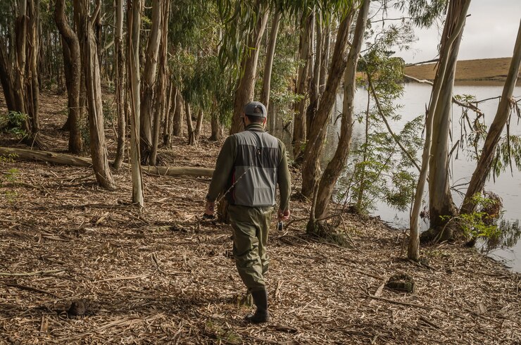 Foto pescador esportivo, pesca no lago em dia nublado.