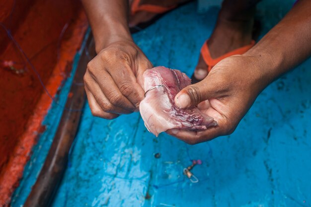 pescador está haciendo gancho cebo para la pesca en barco de pesca