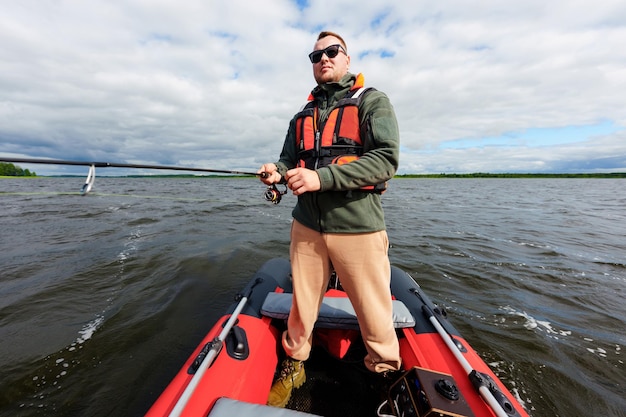 Un pescador está parado en un bote El pasatiempo de un hombre Un día soleado Pescando en el lago