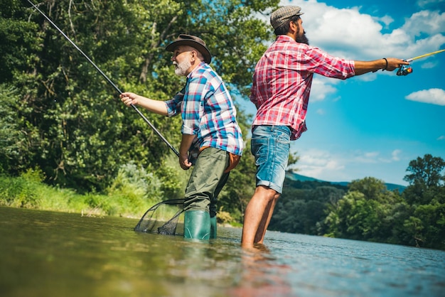 Pescador homens amigos e troféu truta Pai e filho pescando Gerações homens pescando no rio