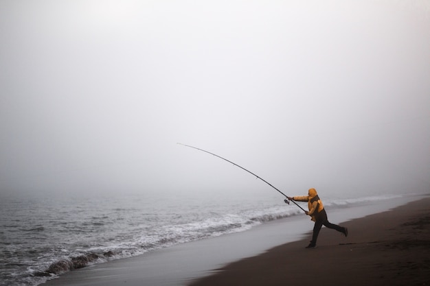 Pescador, jogar, a, vara, ligado, um, praia, com, nevoeiro