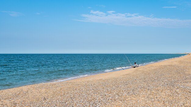 Pescador junto al mar, pescando