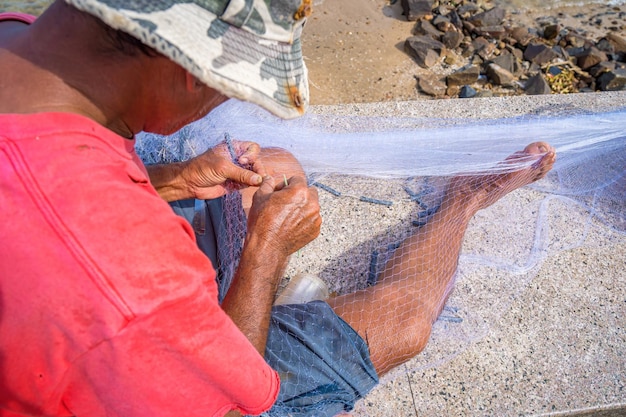 Pescador lançando sua rede ao nascer ou pôr do sol Pescadores tradicionais preparam a rede de pesca Pescadores na praia na Pesca