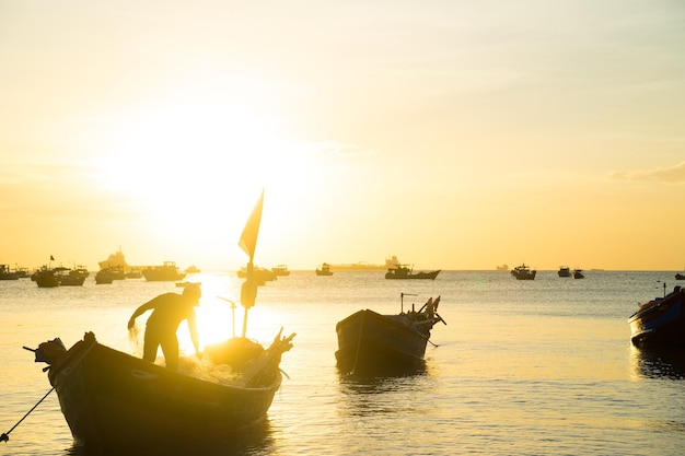 Pescador lançando sua rede ao pôr do sol Pescadores tradicionais preparam a rede de pesca