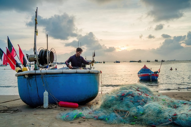 Pescador lanzando su red al amanecer o al atardecer Los pescadores tradicionales preparan la red de pesca