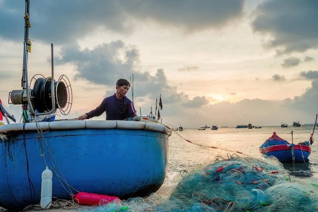 Pescador lanzando su red al amanecer o al atardecer Los pescadores tradicionales preparan la red de pesca