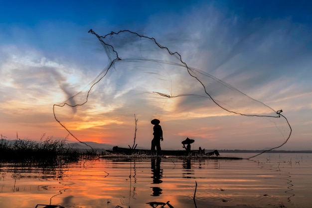 Pescador en la mañana con botes de madera, linternas viejas y redes