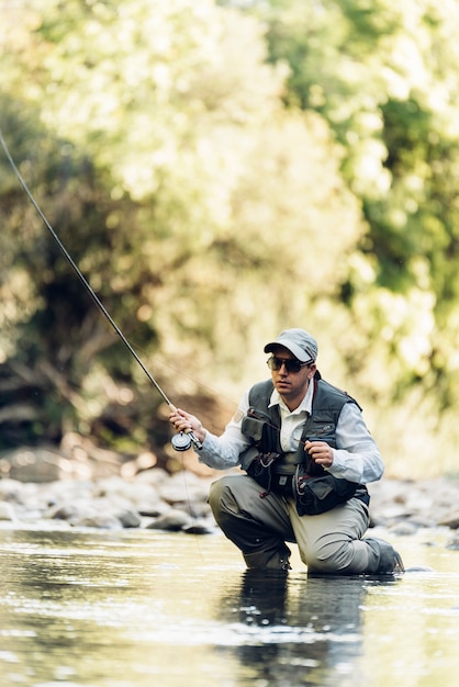 Foto pescador con mosca con caña de pescar con mosca en río hermoso