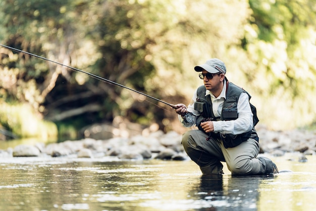 Pescador con mosca con caña de pescar con mosca en río hermoso