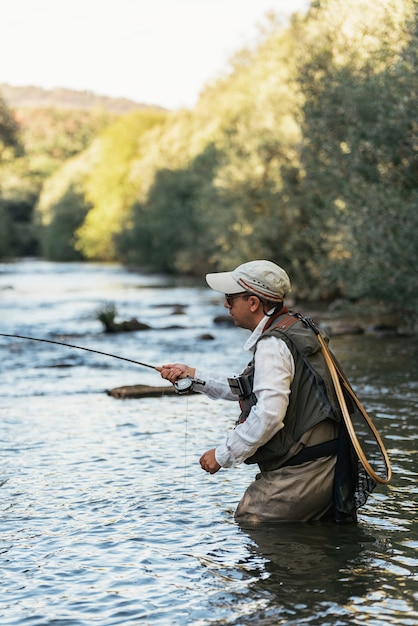 Foto pescador con mosca con caña de pescar con mosca en río hermoso