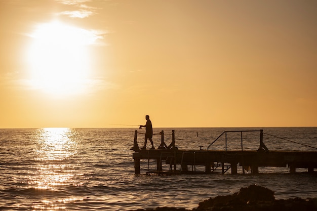 Pescador en el muelle al atardecer en Bayahibe en la República Dominicana