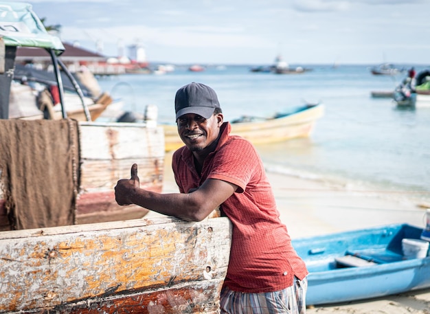 Pescador negro sincero na costa perto do oceano