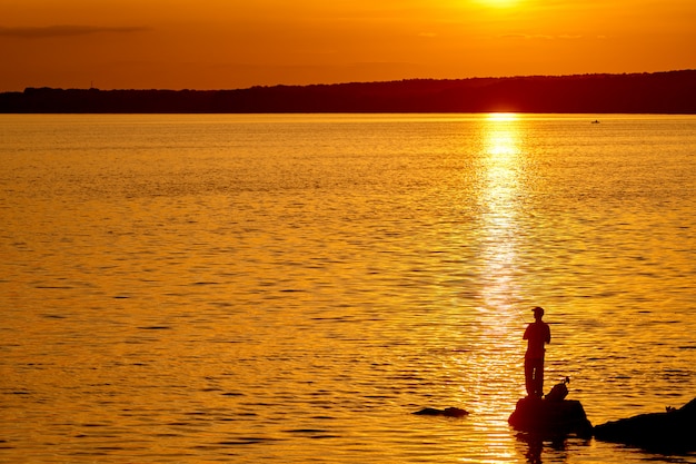 Pescador no cais na hora por do sol