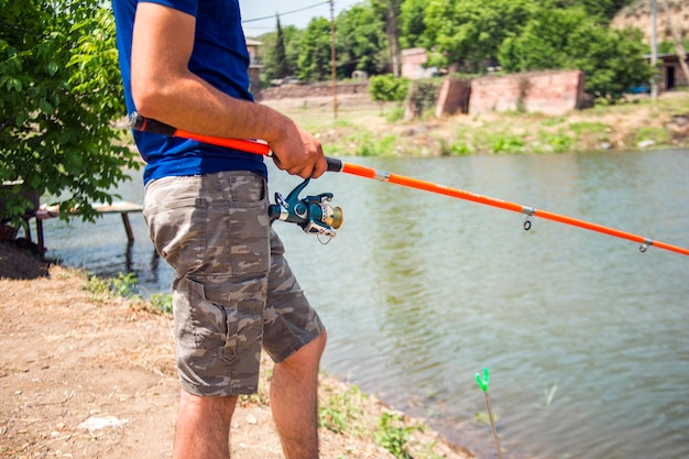 Pescador en la orilla del río Un pescador atrapa un pez Pescador con la mano girando