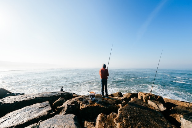 pescador pesca con spinning en el océano