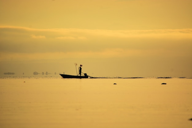 pescador de pie en barco en el mar