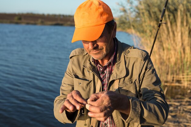 Pescador pone cebo de silicona. Pesca con jig, equipo de silicona.