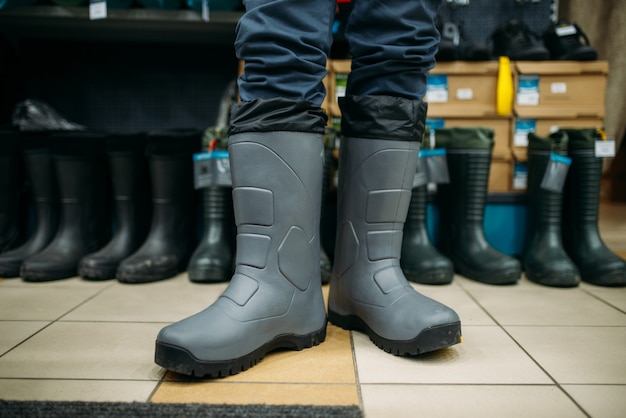 Pescador se prueba botas de goma en la tienda de pesca