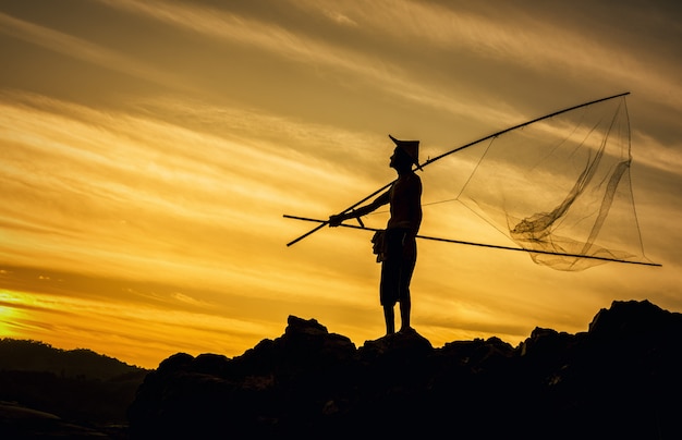 Foto pescador en puesta de sol