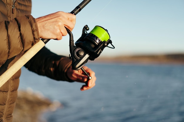 Pescador segurando uma vara de pescar de perto