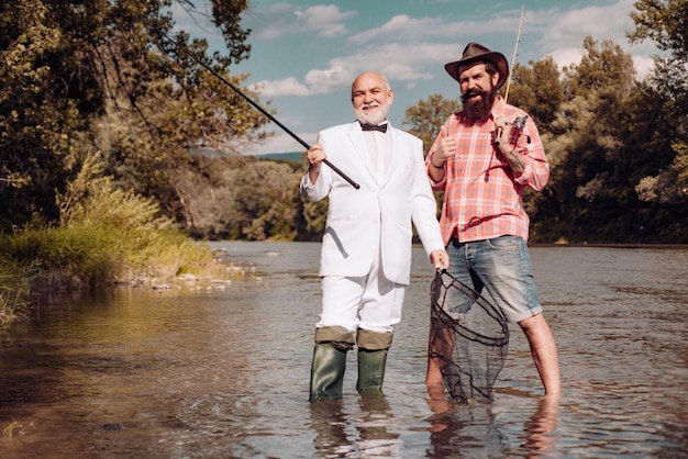 Pescador senior en traje y hombre casual barbudo pescando con caña de pescar