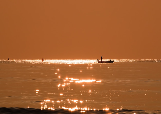 Pescador de silueta pescando mar dorado hermoso brillo natural en la mañana