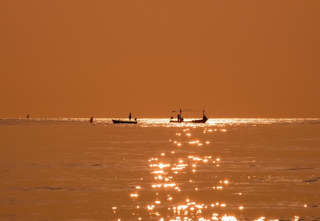 Pescador de silueta pescando mar dorado hermoso brillo natural en la mañana