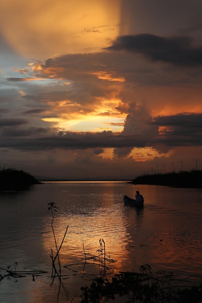 Pescador en su barco al atardecer. Barco de pescadores al atardecer