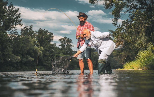 Pescador y trucha trofeo concepto de familia feliz padre e hijo juntos vuelan caña y carrete con una ceja