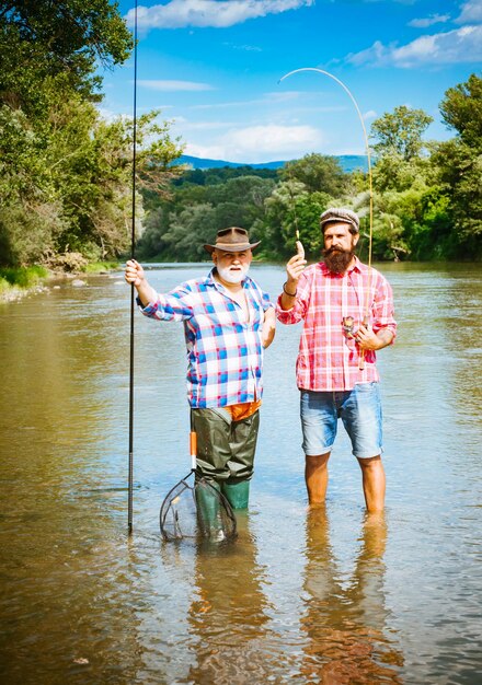 Pescador y trucha trofeo Joven y anciano maduro pesca con mosca Diferencia entre pesca con mosca y pesca regular Pescadores