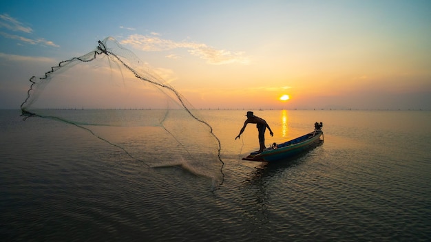 Pescador usa net pegar o peixe no mar