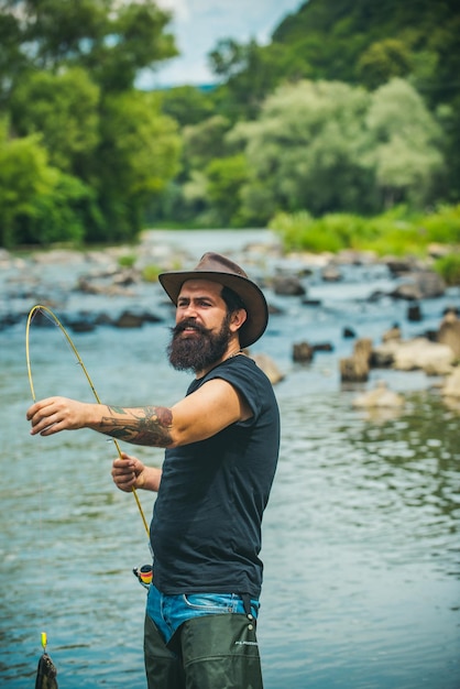 Pescador usando uma vara pescando com mosca em um rio de montanha um pescador de mosca pescando truta selvagem no rio