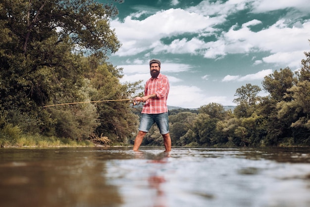 Pescador usando vara de pesca com mosca no rio de montanha um pescador de mosca pescando truta selvagem no rio