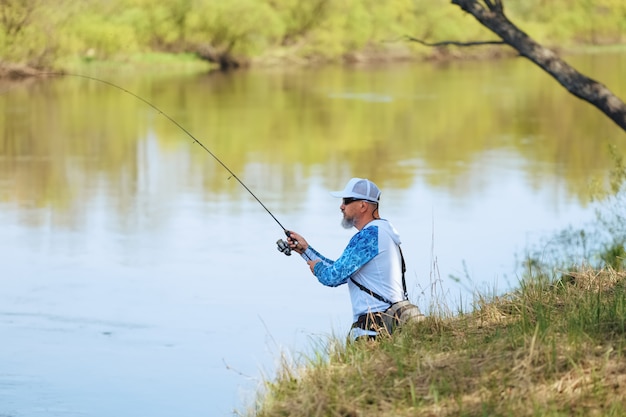 Pescador con una varilla giratoria captura de peces en un río