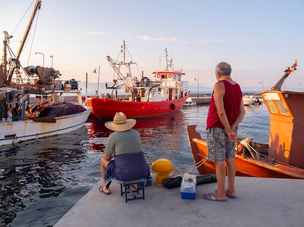 Pescadores e barcos de pesca no porto de Loutra Edipsou na ilha Evia na Grécia