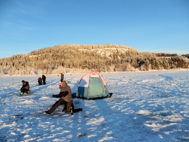 Pescadores e barracas de pesca no gelo de inverno