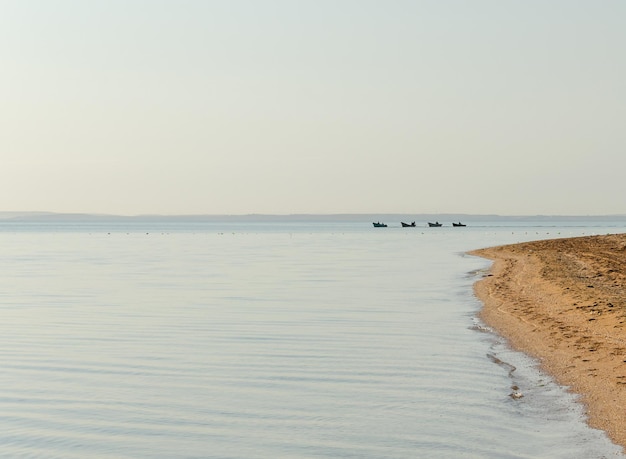 Pescadores em barcos vão para o mar ao amanhecer.