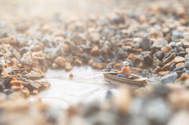 Pescadores em miniatura estão pescando de barco