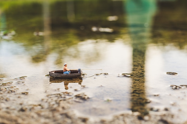 Los pescadores en miniatura están pescando en barco.