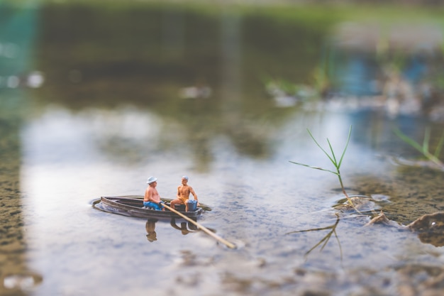 Los pescadores en miniatura están pescando en barco.