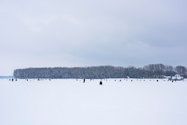 pescadores pegam peixes em um lago congelado na pesca de inverno.