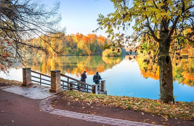 Pescadores pescam na margem do lago no parque Tsaritsyno em Moscou e em árvores multicoloridas