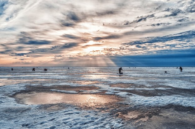 Pescadores pescando ao amanhecer em uma manhã gelada de inverno