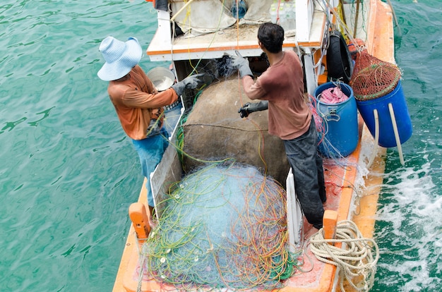 Pescadores tailandeses clasifican captura de día en el puerto LAN de KO y pueblo de pescadores