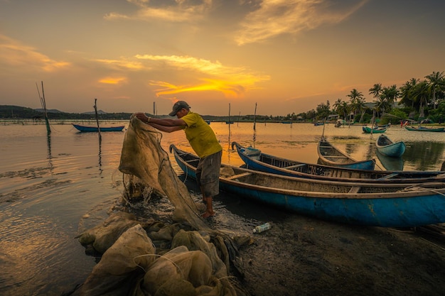 Pescadores tradicionales y barcos en la laguna de O Loan durante la puesta de sol Provincia de Phu Yen Vietnam Concepto de viaje y paisaje